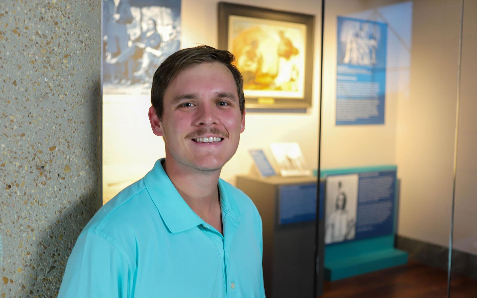 Braeden Martin in front of the display case containing his exhibit.