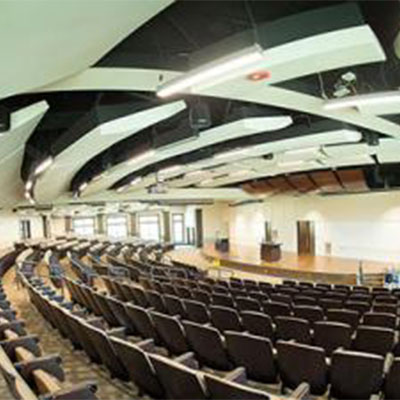 Rows of seats in front of a bright stage with a podium in the center.